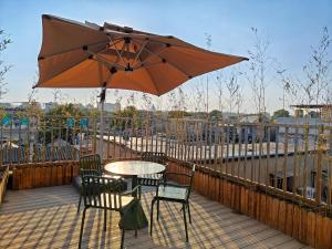 a table and chairs with an umbrella on a deck at QiuGuo Hotel Chao He Beijing Dashilan Xijie Qianmen Subway Station Branch in Beijing