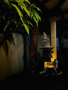 uma árvore em frente a um prédio com uma estátua em R Villa Unawatuna em Unawatuna