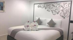 a bedroom with a white bed with white pillows at white house in Phang-nga