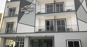 a white building with a sign that reads wine house at white house in Phang-nga