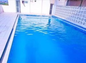 a swimming pool with blue water in a building at Cozy studio at Kisimani Heights Apartment Mombasa in Mombasa