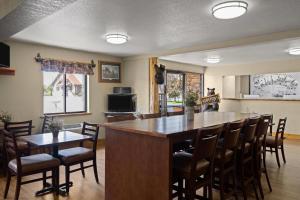 a kitchen with a large bar with chairs around it at Super 8 by Wyndham Kalispell Glacier National Park in Kalispell