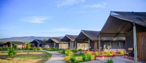 a row of houses with mountains in the background at Endeem mara resort in Ololaimutiek