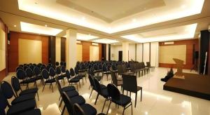una sala de conferencias con sillas y un podio en el centro en Hotel Harmoni Tasikmalaya, en Tasikmalaya
