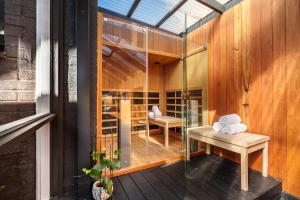 a glass room with a table on a deck at Ocean Grove Luxe Retreat with Pool, Spa and Sauna in Ocean Grove