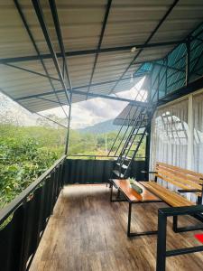 a balcony with a bench and a view of the mountains at Breeze Heven Cabana in Matale +25 photos