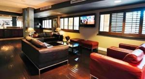 a living room with couches and a flat screen tv at Hotel Solaire Los Angeles in Los Angeles