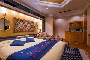 a bedroom with a large bed with red flowers on it at HOTEL C-L'esapce in Honjo