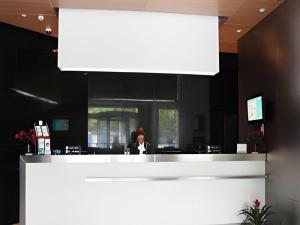 a woman sitting at a counter in a restaurant at Jinjiang Inn Zhangjiagang Yangshe West Street Pedestrian Street in Zhangjiagang
