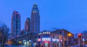 a city street with tall buildings at night at Xana Hotelle· Tianjin Railway Station Jinwan Square Binjiang Avenue in Tianjin
