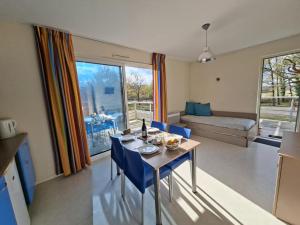 a living room with a table and blue chairs at Cottage Rembrandt in Chaveignes