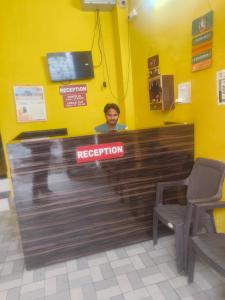 eine Person hinter dem Empfangstresen in einem Restaurant in der Unterkunft Shree mangalam lnn in Prayagraj