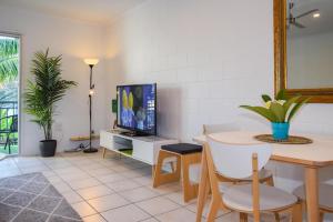 een woonkamer met een tafel en een tv bij Coolview in Cannonvale