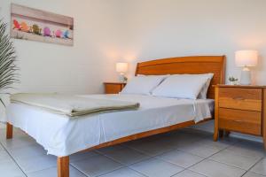 een slaapkamer met een bed en een dressoir met 2 lampen bij Coolview in Cannonvale