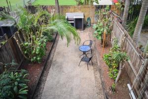 een tuin met een tafel en een bank in een tuin bij Coolview in Cannonvale