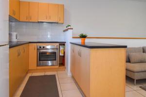 een keuken met een aanrecht en een bank in een kamer bij Coolview in Cannonvale +4 foto's