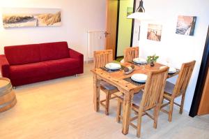Una sala de estar con una mesa de madera y un sofá rojo en Gaffelschoner - ABC613, en Hohen Wieschendorf