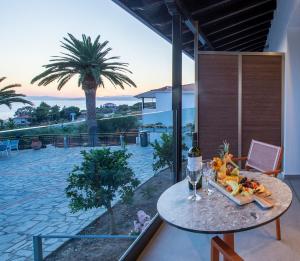 a table with a plate of food on it on a balcony at Aristoteles Holiday Hotel And Spa in Ouranoupoli