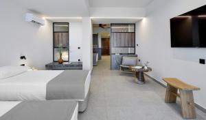 a hotel room with two beds and a television at Aristoteles Holiday Hotel And Spa in Ouranoupoli