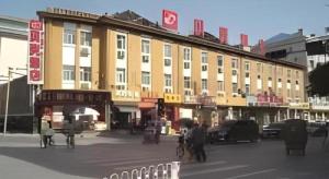 a large building on a street with people in front of it at Shell Baoding Dongfeng Middle Road Kailian Hotel in Baoding