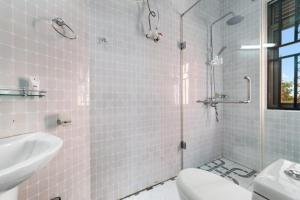 un bagno con doccia, lavandino e WC di Entebbe Hotel a Entebbe