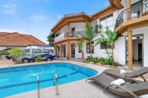 un furgone parcheggiato davanti a una casa con piscina di Entebbe Hotel a Entebbe Altre 13 foto