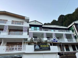 a white building with a sign in front of it at The Naini Inn By ASPien Hotels in Nainital +2 photos