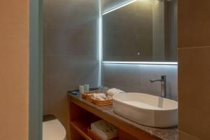 un bagno con lavandino e specchio di Tangyin Courtyard Hotel a Xi'an