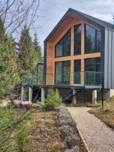 a modern house with a glass facade at Trei Mândre by Cabana CeiTrei in Cozăneşti