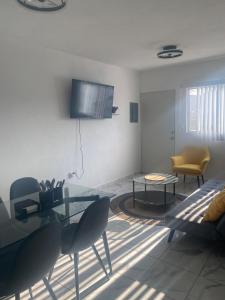 a living room with a table and chairs and a tv at Departamento Premium en Acapulco in La Sabana