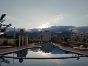 a large swimming pool in a city with a sunset at Departamento Premium en Acapulco in La Sabana