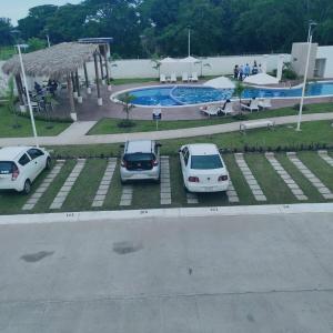 two cars parked in a parking lot next to a pool at Departamento Premium en Acapulco in La Sabana