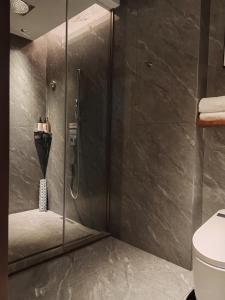 a shower with a glass door in a bathroom at Yuezhi Hotel Longnan Yingbin Avenue Branch in Magutang