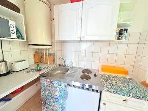 a kitchen with white cabinets and a sink at Ferienhaus Nele - ein strandnahes, einfaches Haus in Breege