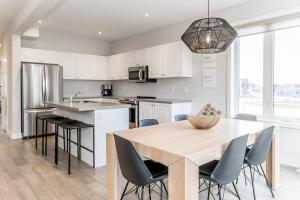 eine Küche mit einem großen Holztisch und Stühlen in der Unterkunft Modern Luxury Townhome Walk to Blue Shuttle in Blue Mountains