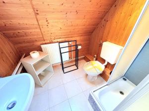 a bathroom with a wooden ceiling with a toilet and a sink at Ferienhaus Nele - ein strandnahes, einfaches Haus in Breege +15 photos