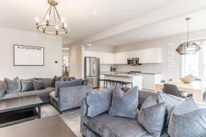 ein Wohnzimmer mit Sofas und eine Küche in der Unterkunft Modern Luxury Townhome Walk to Blue Shuttle in Blue Mountains
