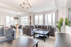 ein Wohnzimmer mit Sofa und Tisch in der Unterkunft Modern Luxury Townhome Walk to Blue Shuttle in Blue Mountains