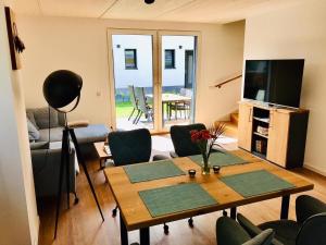 a living room with a table and a television at Ferienhaus BUG - zwischen Bodden und Meer in Dranske