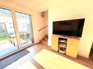 ein Wohnzimmer mit einem großen Flachbildfernseher in der Unterkunft Ferienhaus Bug in Dranske