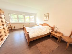 Ferienhaus zum Kranichblick في Garz: غرفة نوم بها سرير وطاولة ونافذة
