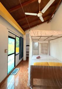 ウェリガマにあるWeligama Imal Guest Houseのベッドと天井扇風機のある寝室