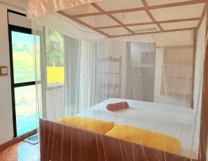 a bedroom with a large white bed with a window at Weligama Imal Guest House in Weligama