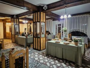 a dining room with two tables and a fireplace at Hotel Claris in Văliug