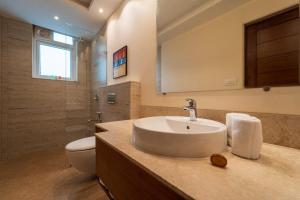 a bathroom with a sink and a toilet at Luxury Retreat Evoke 2Bhk Apts in Candolim +19 photos