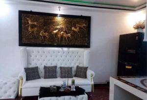 ein Wohnzimmer mit einem weißen Sofa und einem Gemälde an der Wand in der Unterkunft KrizLion Hotel in Hinatuan