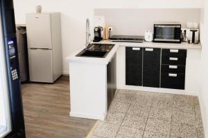 eine Küche mit einem weißen Kühlschrank und einer Mikrowelle in der Unterkunft Work & Stay KemptenCityHost in Kempten