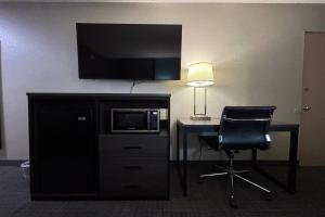 a room with a desk with a microwave and a tv at Super 8 by Wyndham Belleville St. Louis Area in Belleville +15 photos