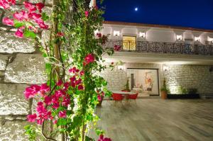 una casa con flores rosas delante de ella en Alaçatı The Design Hotel, en Alacati