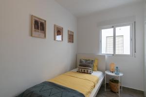 a small bedroom with a bed and a window at Satu Granada Modern Apartment in the Albaicín in Granada